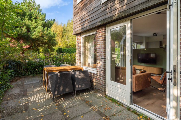 Zonnig terras Boszicht 17 met zitje aan bosrand Schiermonnikoog.