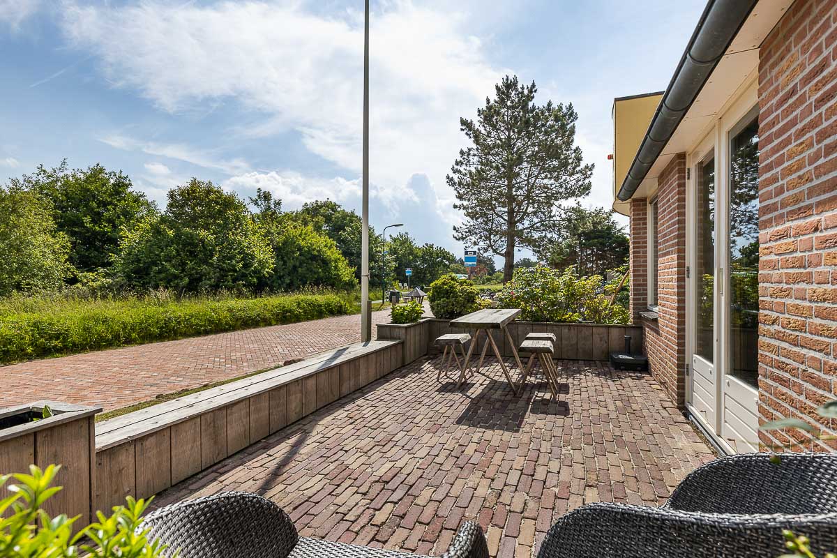 Terras met weids uitzicht over duinen bij vakantiehuis Boszicht 16a op Schiermonnikoog